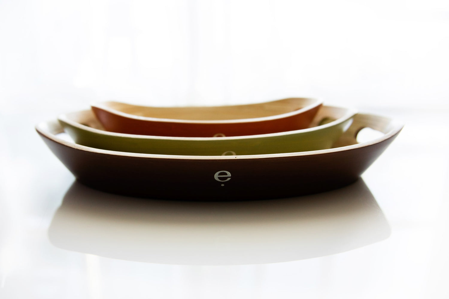 Top down stacked set of 3 natural spun bamboo oval Montessori trays demonstrating size