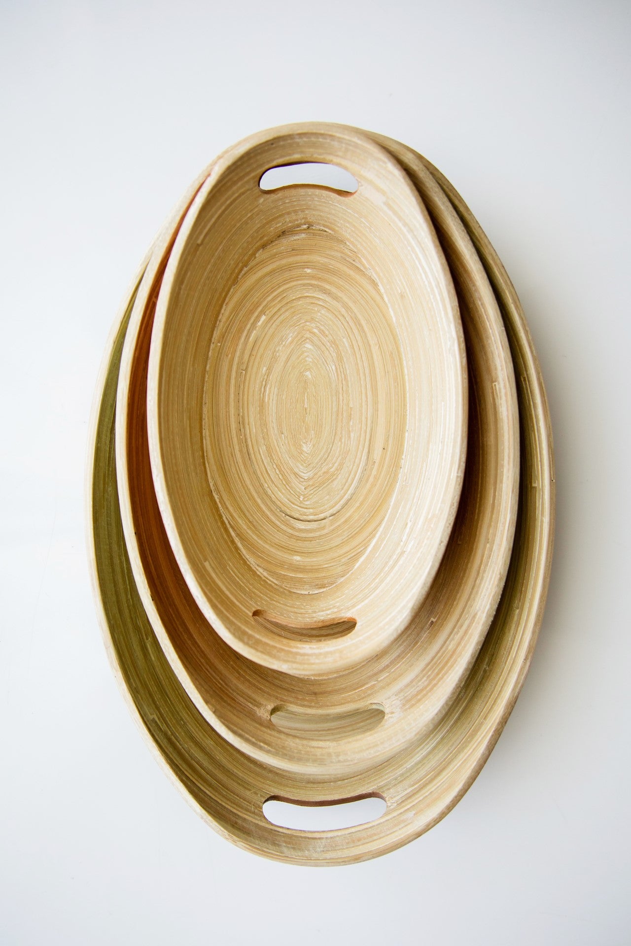 Top down stacked set of 3 natural spun bamboo oval Montessori trays demonstrating texture