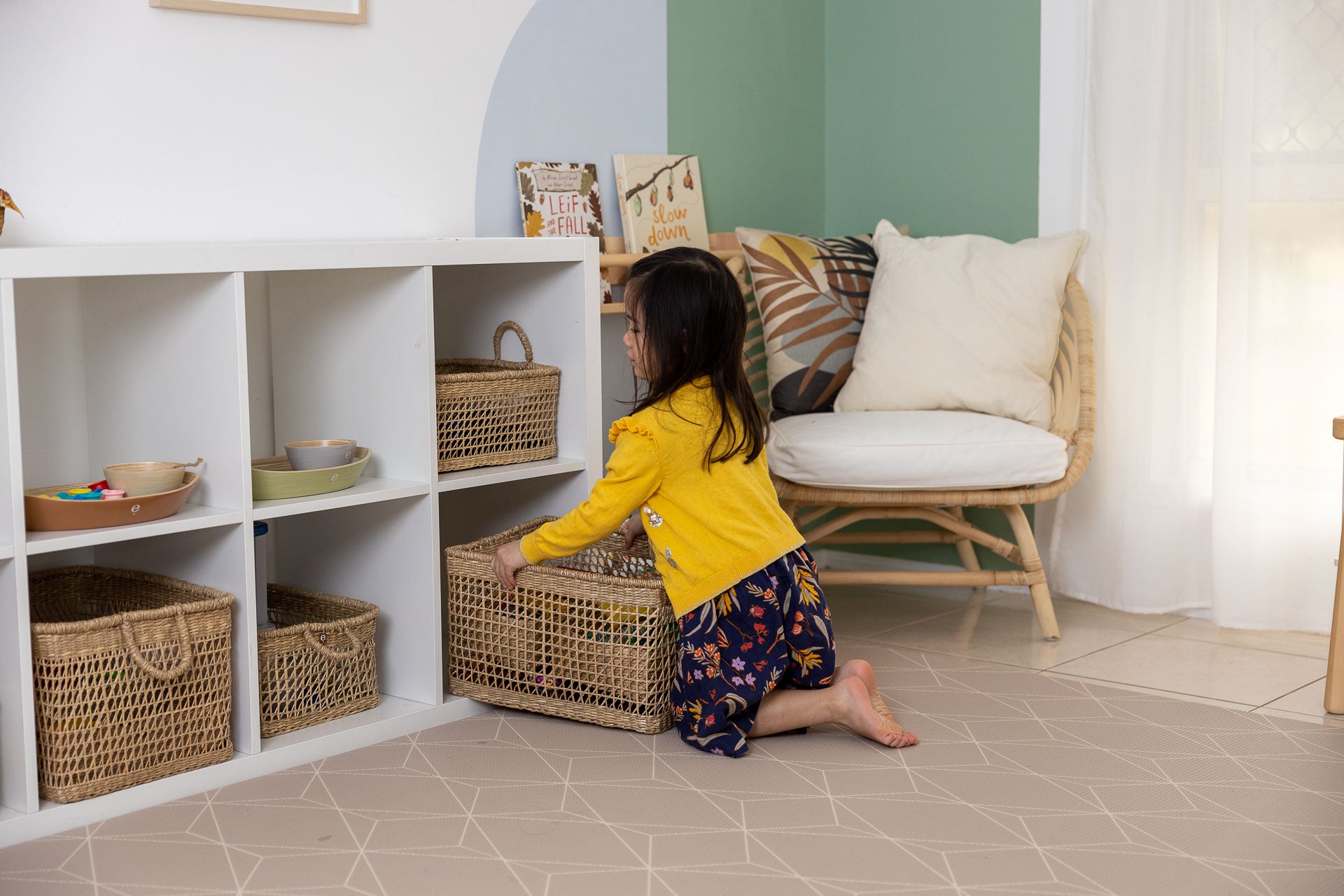 Toddler packing away toys in a Montessori play space