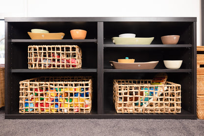 Showcase of Montessori baskets and trays on an IKEA Besta shelf