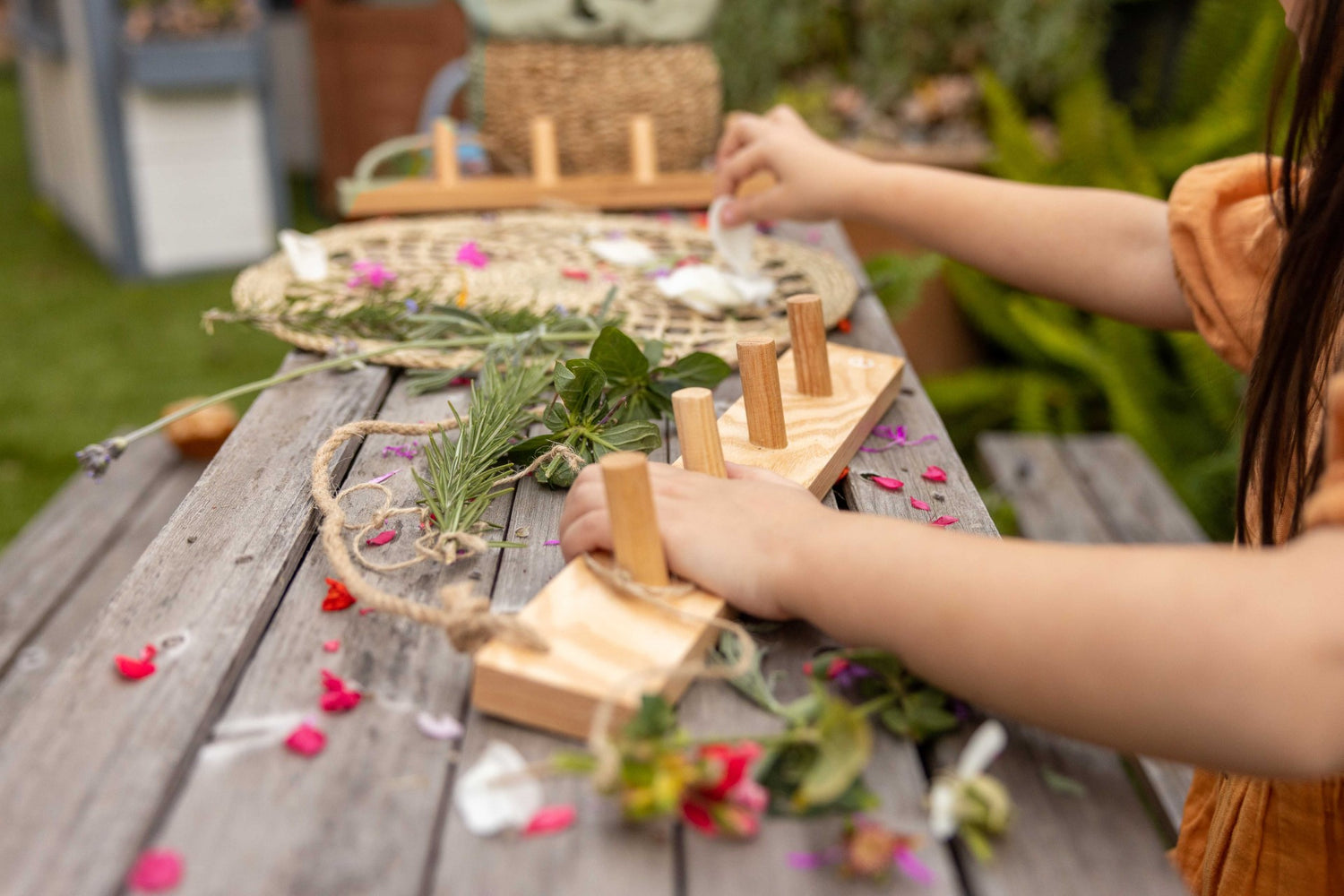 Child engaging in outdoor play with wall hanger and fresh flowers