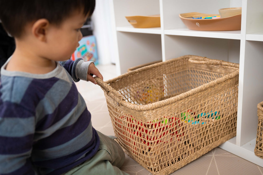 Child pulling Seagrass Basket from Ikea Kallax shelf - Montessori toy storage