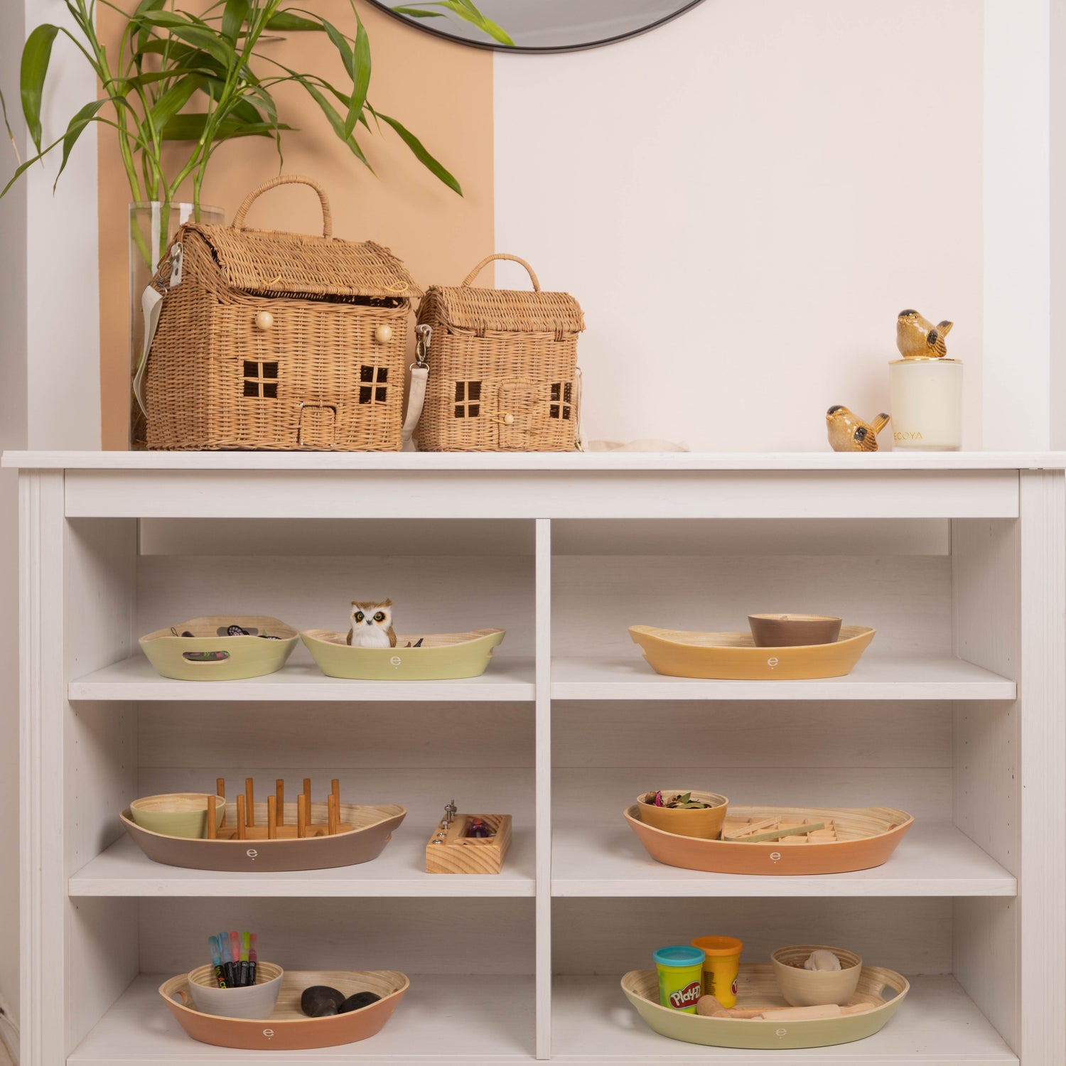 orderly, calm and neutral Montessori shelf filled with natural spun bamboo trays and bowls holding an assortment of Montessori activities