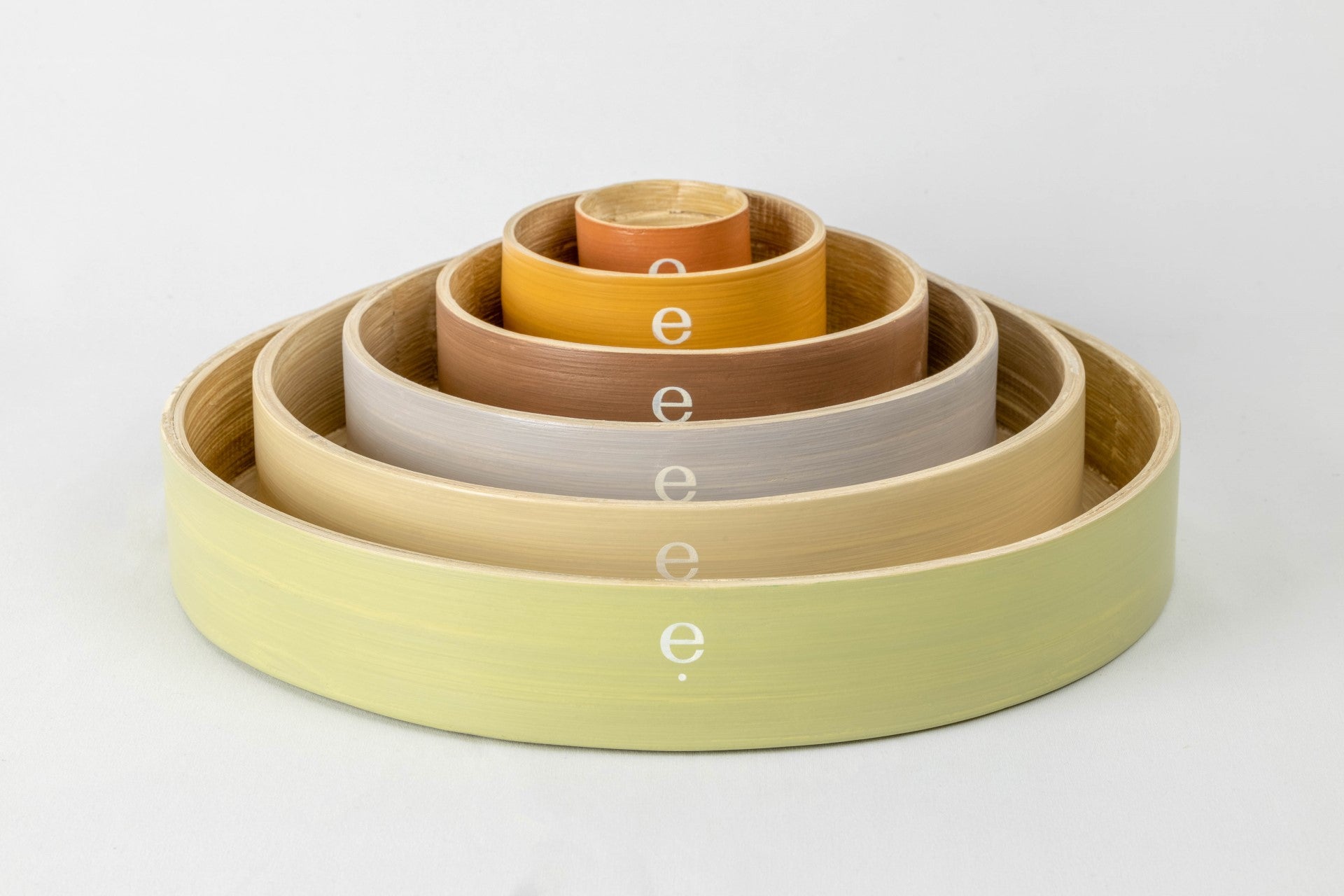 Image of stacked 6 set circular spun bamboo Montessori tray set with elephlay logo facing forward