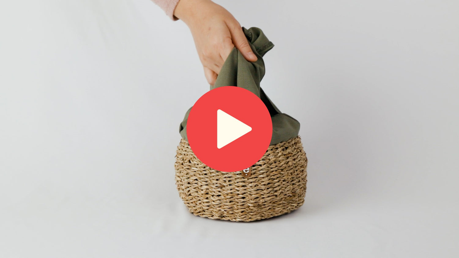 Video of hands tying, lifting and placing handle inside an outdoor Montessori basket