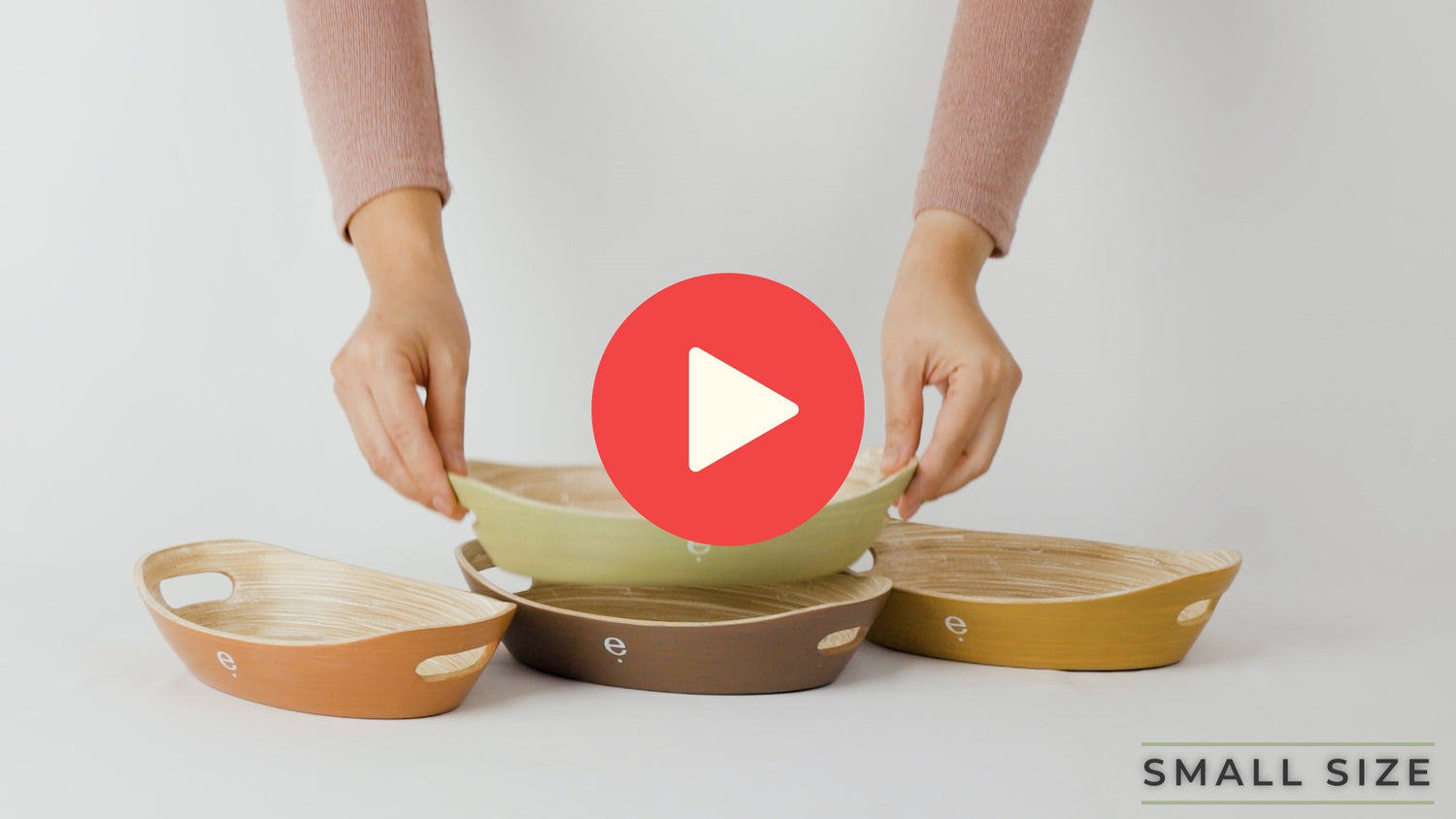 Video of small natural oval spun bamboo trays being stacked